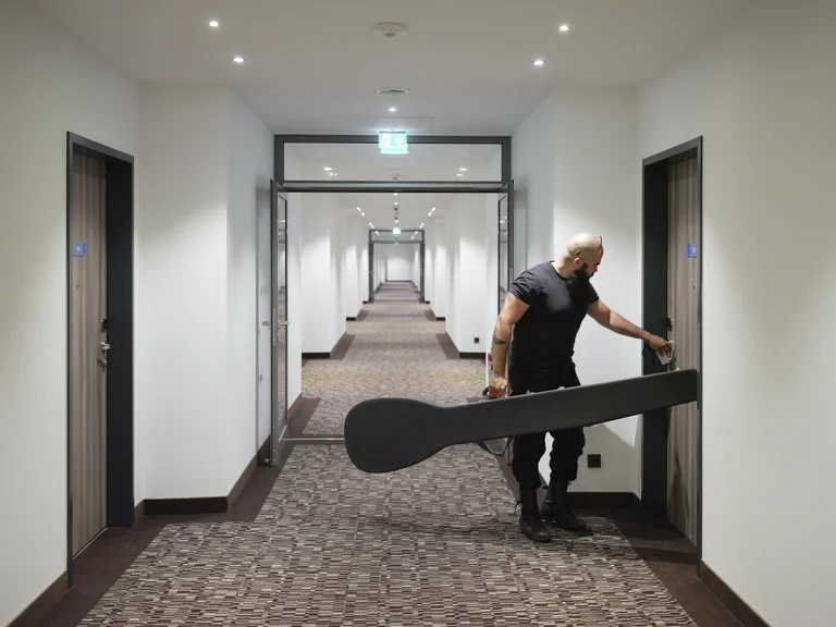 Musiker mit Gambe im Hotelflur