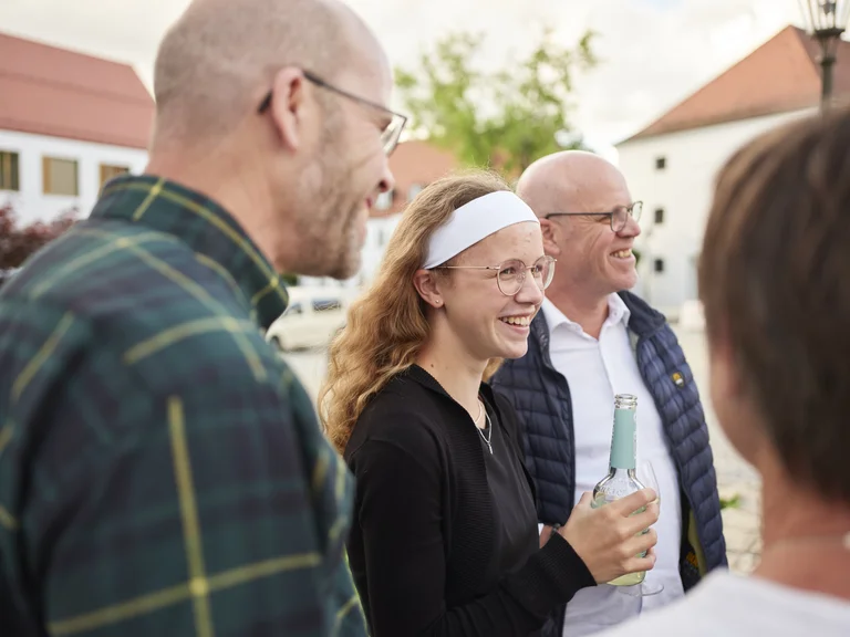 Lachende Besuchergruppe vor dem Historischen Reitstadel