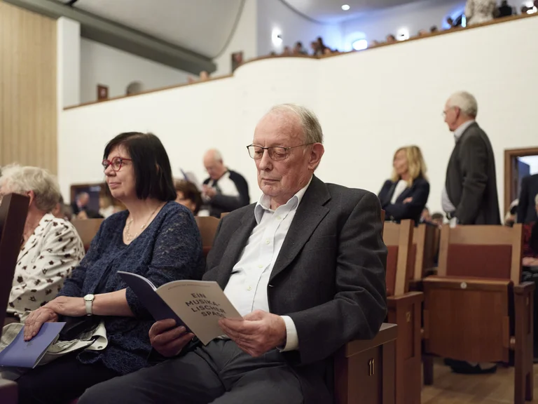 Besucher blättert im Abendprogramm
